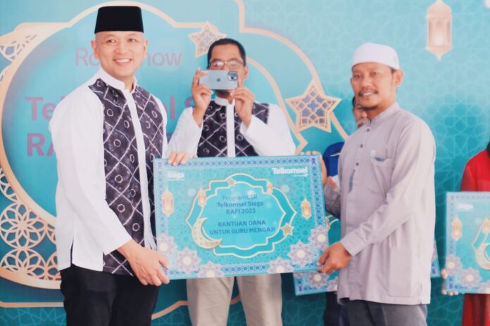 Telkomsel Siaga RAFI 2023_2: Komisaris Telkomsel Yose Rizal (kiri) secara simbolis menyerahkan bantuan dana kepada guru mengaji pada momen Roadshow Telkomsel Siaga Ramadan dan Idulfitri di Banjarmasin Kalimantan Selatan, Senin (3/4).